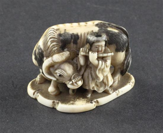 A Japanese ivory netsuke of a figure playing the flute standing by an ox, 19th century, 4.4cm